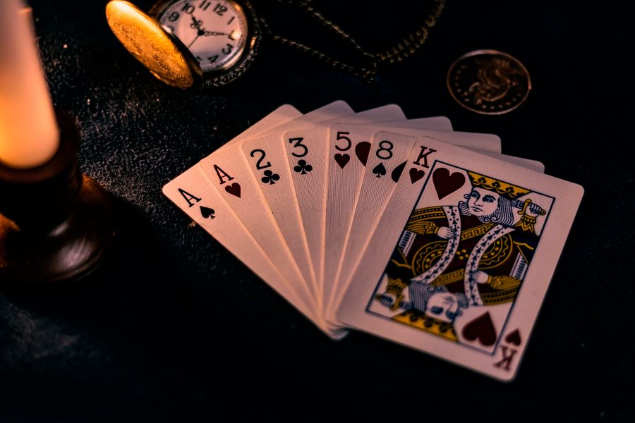 Kartu remi tergeletak di meja kasino sebagai ilustrasi kategori slot online